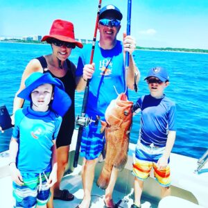 Family with a "baqueta" or red snapper